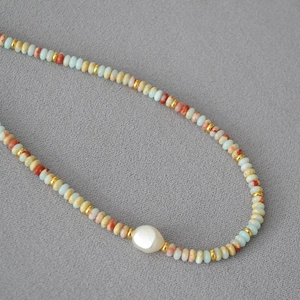 Retro beaded necklace with blue stones, golden accents and a baroque pearl centerpiece
