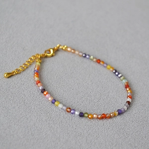Close-up of colorful natural stone beaded bracelet with gold lobster clasp and chain
