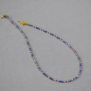 Détail des perles de lapis-lazuli et agates rouges sur un collier vintage fait main