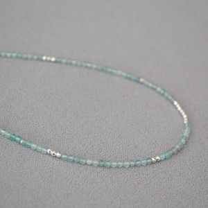 Macro detail of delicate light blue aquamarine beads and silver spacers on the chain