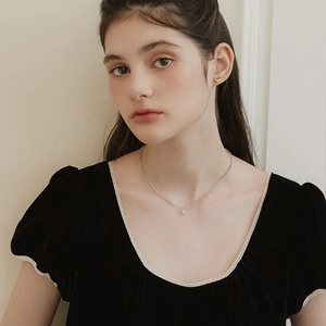 Delicate gold star pendant necklace with grey moonstone beads worn on a model