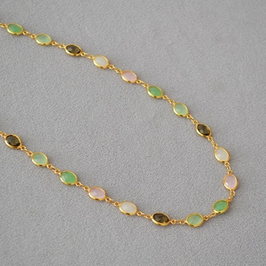 Detailed macro view of faceted multi-colored gemstones on a gold-plated brass chain