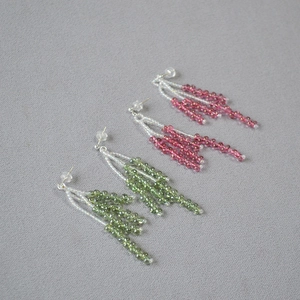 Detail of handmade crystal beaded tassel earrings in olive green and pink with silver needles