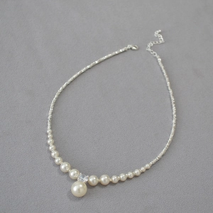 Minimalist pearl necklace with silver beads and shimmering cubic zirconia pendant detail