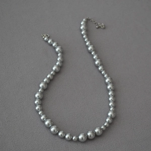 Vintage silver grey faux pearl bead necklace with irregular beads on textured grey surface