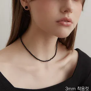 Dettaglio della collana con perle di agata nera da 3mm e orecchini coordinati su modella