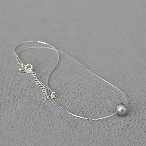 Minimalist gold-plated thin wire necklace with a gray imitation pearl on a refined chain