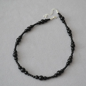 Detail of handmade black onyx beaded necklace with silver lobster clasp and extender chain