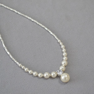 Detail of cream gradient pearls and sparkling zircon pendant on silver beaded chain