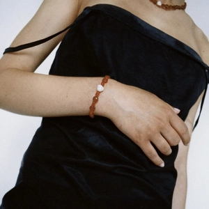Détail d'un collier de perles d'agate rouge et perle baroque porté par un mannequin