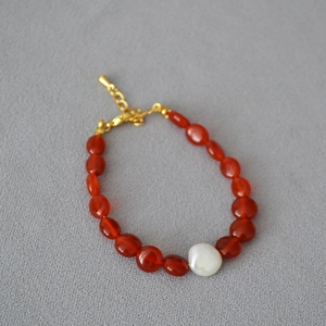 Détail macro de perles de cornaline rouge et perle baroque sur un collier vintage