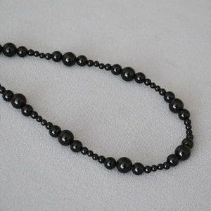 Elegant beaded necklace with polished black onyx stones in a gradient size arrangement