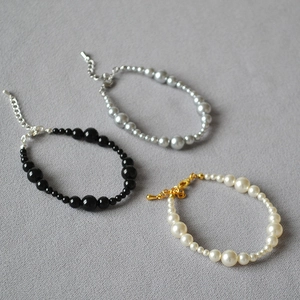 Detail of beaded bracelets with gradient white black and grey faux pearls and clasps