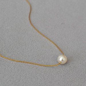 Minimalist gold plated necklace with a single round white pearl pendant on fine chain