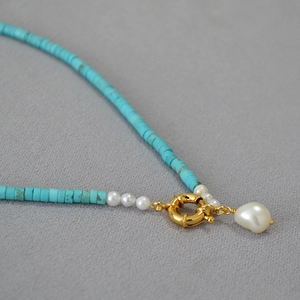 Close-up of turquoise beads with freshwater baroque pearl pendant and golden clasp