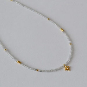 Macro detail of faceted grey moonstone beads and a sparkling star pendant necklace