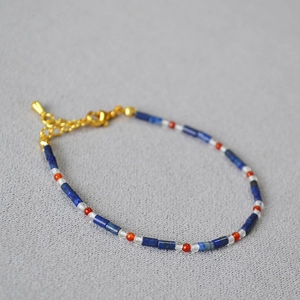 Detailed macro view of beaded bracelet with lapis lazuli, agate, and pearls with gold clasp
