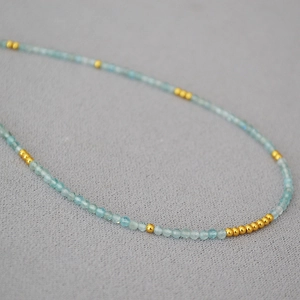 Macro shot of minimalist aquamarine beaded necklace with 18K gold-plated accents
