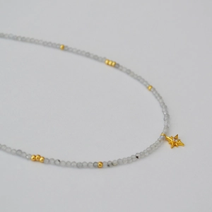 Minimalist grey moonstone beaded necklace featuring a sparkling gold star pendant