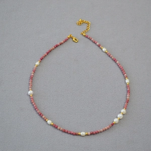 Detail of pink stone beads and freshwater pearls necklace with gold adjustable clasp
