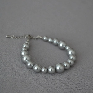 Detail of silver-grey pearl bracelet with alternating bead sizes and lobster clasp