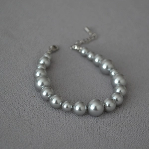Detailed view of grey gradient faux pearl necklace with silver-tone lobster clasp closure