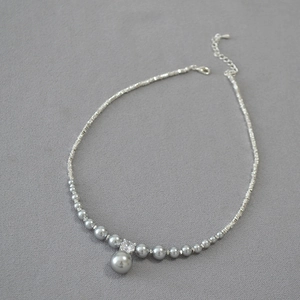 Detail of grey pearl necklace with gradient beads and sparkling zircon pendant