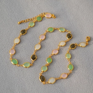 Detail of colorful faceted crystal necklace with gold-plated brass chain and lobster clasp