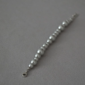 Detail of silver grey gradient pearl necklace with lobster clasp and extension chain