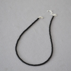 Dettaglio della collana di perle di onice nera con chiusura a moschettone in argento