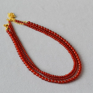 Vue détaillée du collier triple rang en agate rouge avec fermoir doré réglable