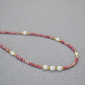 Macro detail of French style pink quartz beads and freshwater pearls on a fine necklace
