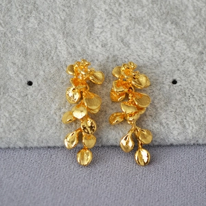 Close-up of vintage gold leaf tassel earrings with multi-layered floral petal structure