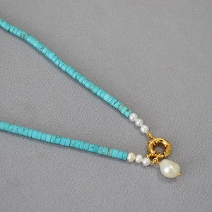 Detail of turquoise beads with irregular baroque pearl pendant on gold spring clasp
