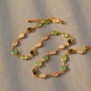Detail of colorful faceted crystal gemstones on a gold-plated brass necklace chain