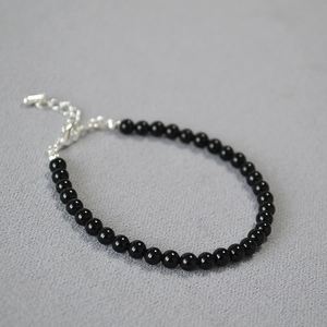 Close-up of minimalist black onyx beaded bracelet with adjustable silver lobster clasp