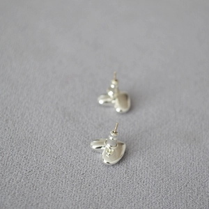 Minimalistische silberne Herz-Ohrstecker mit poliertem Finish auf grauem Stoff