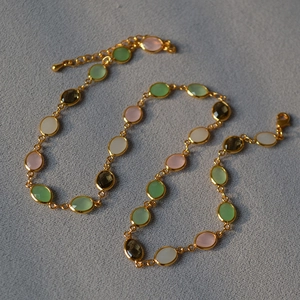 Detail of colorful faceted crystal gemstones on a gold-plated brass necklace chain