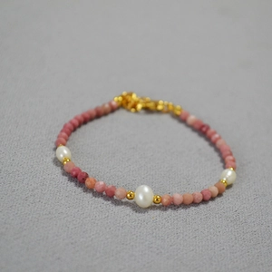 Detail of pink beaded necklace with oval freshwater pearls and gold lobster clasp