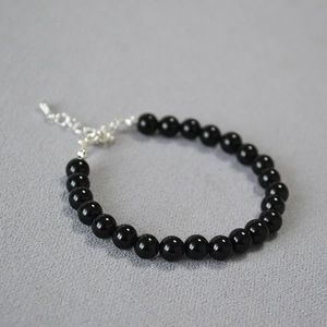 Detailed shot of beaded bracelet with black onyx stones and silver adjustable metal clasp