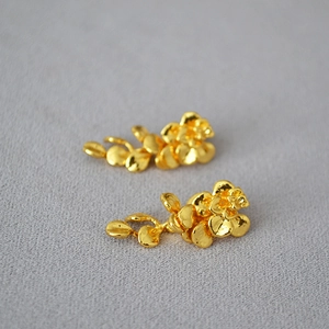 Detailed close-up of gold leaf tassel earrings featuring hand-hammered metal textures