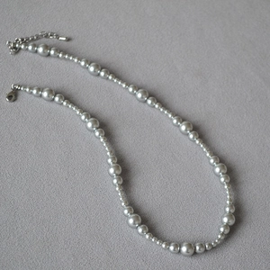 Close-up of elegant silver-gray gradient beaded necklace with adjustable metal lobster clasp