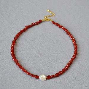 Détail des perles d'agate rouge et perle baroque avec fermoir mousqueton doré réglable