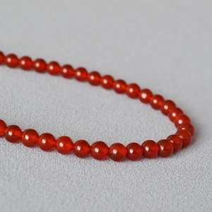 Détail macro de perles en agate rouge translucide avec un fini poli et un lustre huileux
