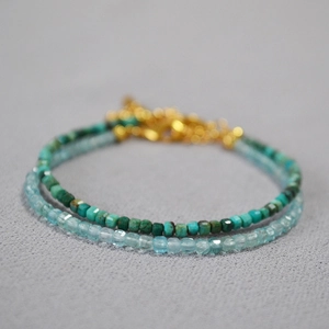 Macro shot of double-layer beaded bracelet with turquoise and aquamarine cube charms