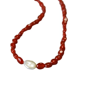 Collier vintage avec perles d'agate rouge et une perle baroque blanche sur fond blanc