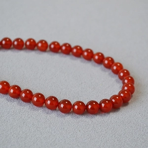 Vue macro de perles en agate rouge translucide à texture lisse et teinte cramoisie