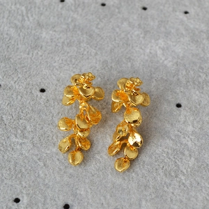 Detail of gold leaf tassel earrings with layered round sequins and metallic luster