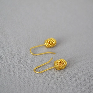 Elegant gold-plated pine cone drop earrings with textured finish on light gray background