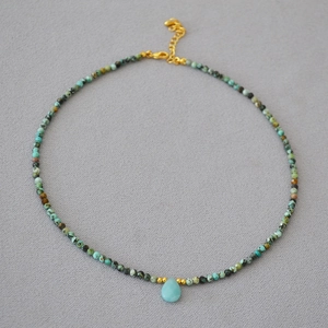 Detail of bohemian turquoise beaded necklace with light blue teardrop stone pendant